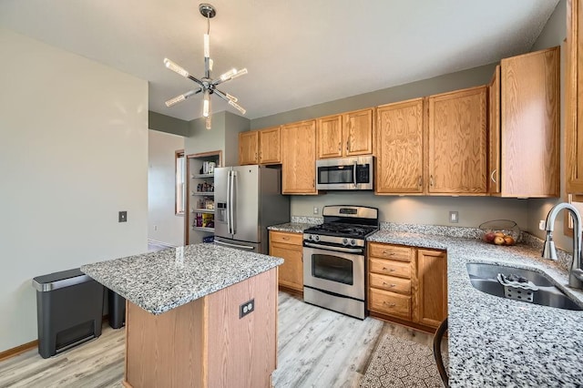 6788 Carlisle Curv, Shakopee, MN 55379 - kitchen featuring appliances with stainless steel finishes, light wood-style floors, a center island, light stone countertops, and a chandelier