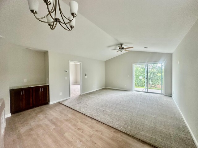 720 Cherrywood Ln NE, Isanti, MN 55040 - unfurnished living room featuring a ceiling fan, vaulted ceiling, light wood finished floors, a chandelier, and light carpet