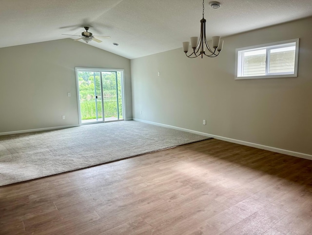720 Cherrywood Ln NE, Isanti, MN 55040 - spare room featuring a ceiling fan, a chandelier, healthy amount of natural light, lofted ceiling, and wood finished floors
