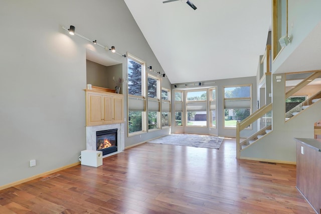 10902 Eagle Lake Blvd, Maple Grove, MN 55369 - unfurnished living room with high vaulted ceiling, a glass covered fireplace, healthy amount of natural light, wood finished floors, and stairs