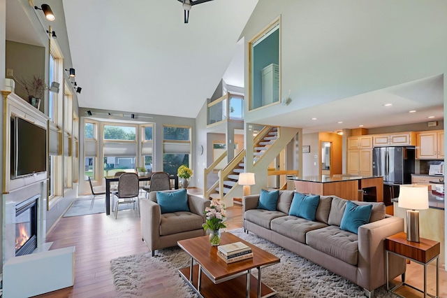 10902 Eagle Lake Blvd, Maple Grove, MN 55369 - living room with a high ceiling, light wood finished floors, stairway, a glass covered fireplace, and recessed lighting