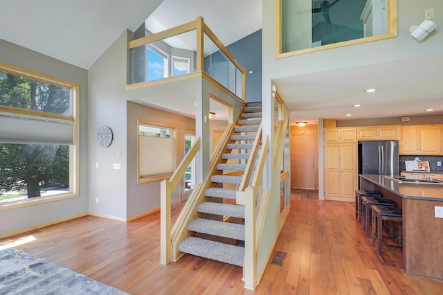 10902 Eagle Lake Blvd, Maple Grove, MN 55369 - staircase with high vaulted ceiling, hardwood / wood-style flooring, and recessed lighting