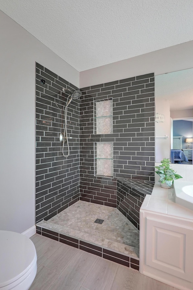 10902 Eagle Lake Blvd, Maple Grove, MN 55369 - ensuite bathroom featuring a tile shower, vanity, wood finished floors, and a textured ceiling