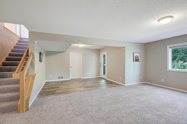 10902 Eagle Lake Blvd, Maple Grove, MN 55369 - unfurnished living room featuring carpet flooring, stairway, a textured ceiling, and wood finished floors