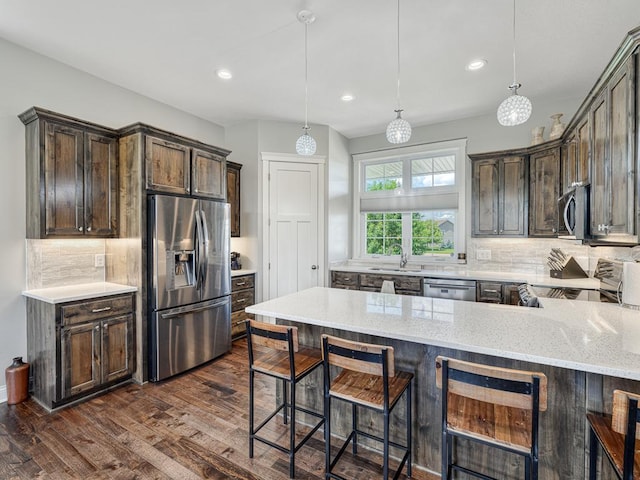 6937 94th St S, Cottage Grove, MN 55016 - kitchen with stainless steel appliances, dark brown cabinets, light stone counters, dark wood-style flooring, and tasteful backsplash
