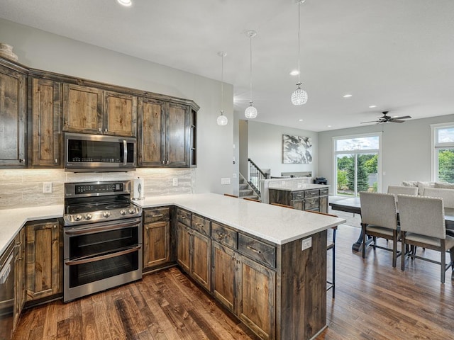 6937 94th St S, Cottage Grove, MN 55016 - kitchen featuring stainless steel appliances, open floor plan, dark wood finished floors, backsplash, and recessed lighting