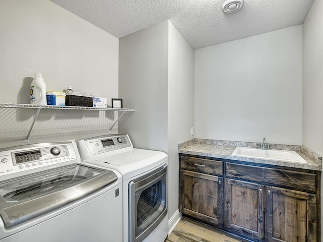 6937 94th St S, Cottage Grove, MN 55016 - laundry area featuring separate washer and dryer, light wood-style flooring, cabinet space, and a textured ceiling