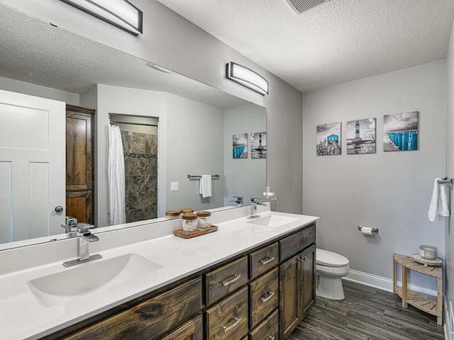 6937 94th St S, Cottage Grove, MN 55016 - bathroom with double vanity, a textured ceiling, wood finished floors, and curtained shower