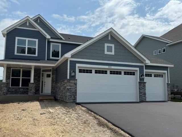 7200 Auburn Ln, Inver Grove Heights, MN 55077 - craftsman inspired home featuring stone siding, an attached garage, asphalt driveway, and a porch