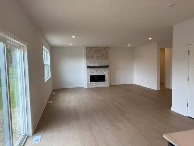 7200 Auburn Ln, Inver Grove Heights, MN 55077 - unfurnished living room featuring healthy amount of natural light, light wood-style flooring, recessed lighting, and a large fireplace