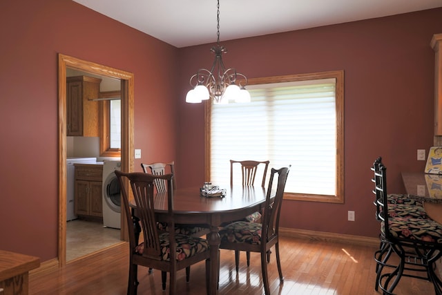 21601 Timber Hills Trl, Nisswa, MN 56468 - dining area featuring a chandelier, light wood finished floors, and washer / dryer