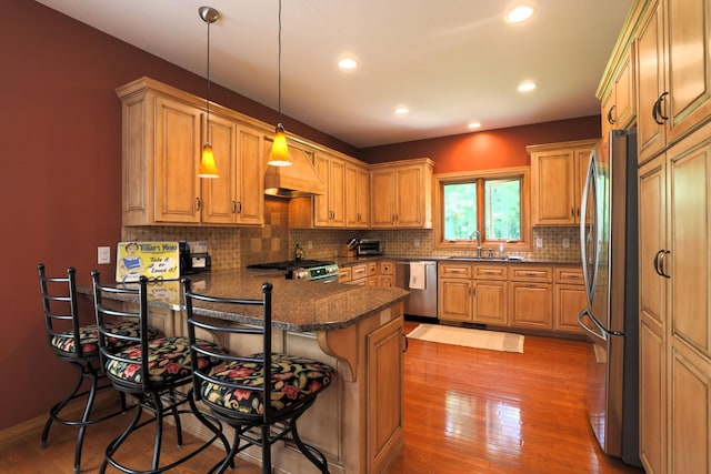21601 Timber Hills Trl, Nisswa, MN 56468 - kitchen with appliances with stainless steel finishes, a peninsula, light wood-style floors, backsplash, and recessed lighting