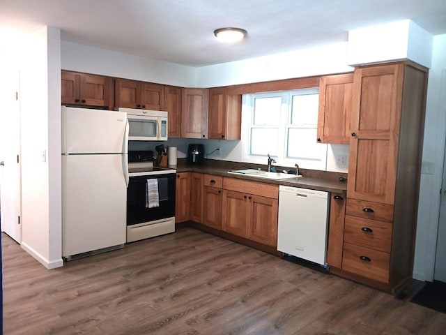 1235 Mitchell Pl, Fergus Falls, MN 56537 - kitchen featuring white appliances, dark countertops, dark wood finished floors, and brown cabinetry