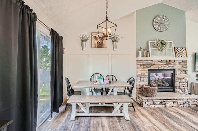 1301 English Ave NW, New Prague, MN 56071 - dining space featuring vaulted ceiling, a textured ceiling, a decorative wall, a chandelier, and wood finished floors