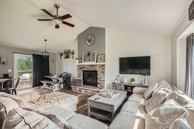1301 English Ave NW, New Prague, MN 56071 - living area featuring lofted ceiling, wood finished floors, a ceiling fan, and a stone fireplace