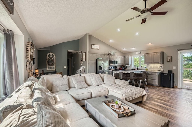 1301 English Ave NW, New Prague, MN 56071 - living area with vaulted ceiling, a ceiling fan, wood finished floors, and recessed lighting