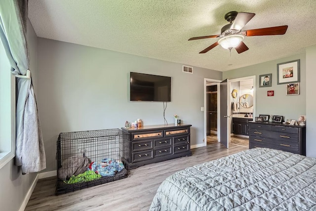 1301 English Ave NW, New Prague, MN 56071 - bedroom featuring a textured ceiling, wood finished floors, ensuite bathroom, and a ceiling fan