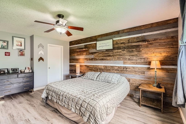 1301 English Ave NW, New Prague, MN 56071 - bedroom featuring a textured ceiling, wooden walls, wood finished floors, and ceiling fan