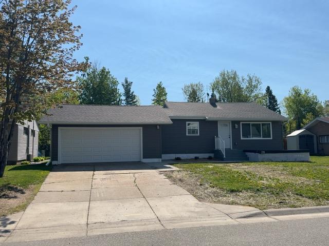 20 Erie St, Aurora, MN 55705 - view of front of property with an attached garage, concrete driveway, and a front yard