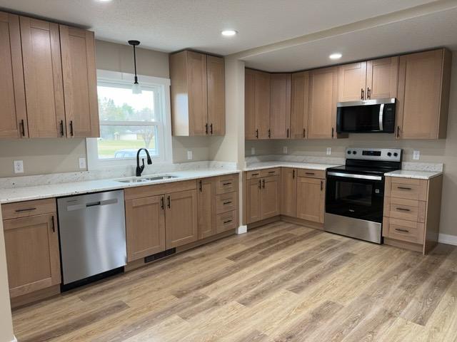20 Erie St, Aurora, MN 55705 - kitchen featuring appliances with stainless steel finishes, light wood-type flooring, recessed lighting, and decorative light fixtures
