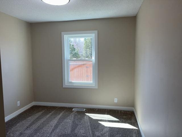 20 Erie St, Aurora, MN 55705 - empty room featuring dark colored carpet and a textured ceiling