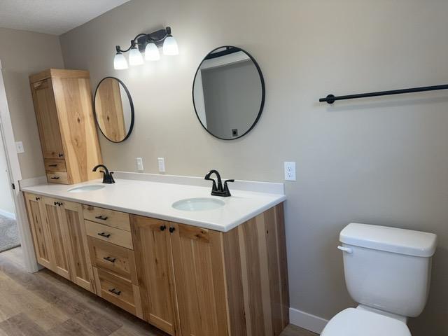 20 Erie St, Aurora, MN 55705 - bathroom featuring double vanity and wood finished floors