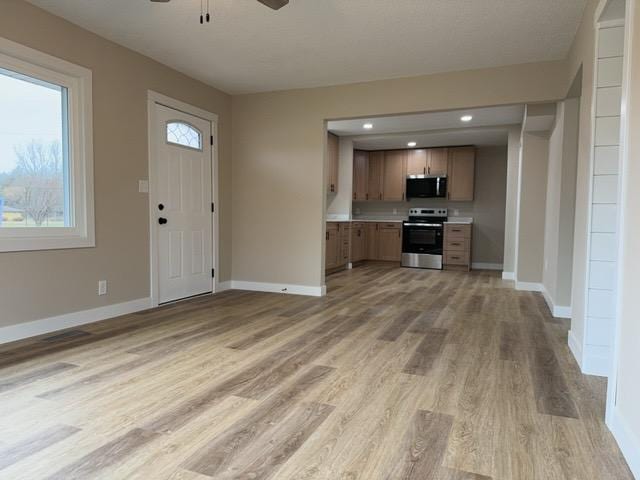 20 Erie St, Aurora, MN 55705 - kitchen featuring appliances with stainless steel finishes, a ceiling fan, light wood-type flooring, light countertops, and open floor plan