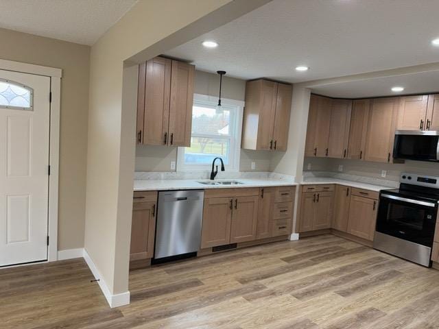 20 Erie St, Aurora, MN 55705 - kitchen featuring stainless steel appliances, light wood-type flooring, light countertops, hanging light fixtures, and recessed lighting