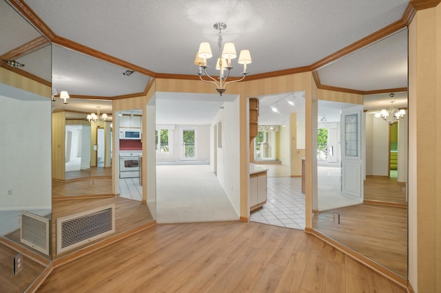 5011 Lake Ave Unit 105, White Bear Lake, MN 55110 - unfurnished dining area featuring a chandelier, crown molding, light wood-style floors, a textured ceiling, and healthy amount of natural light