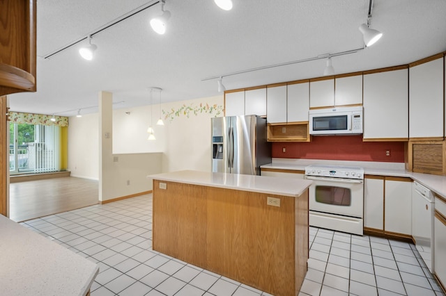 5011 Lake Ave Unit 105, White Bear Lake, MN 55110 - kitchen with track lighting, white appliances, a kitchen island, light countertops, and light tile patterned floors