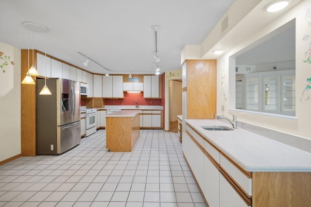 5011 Lake Ave Unit 105, White Bear Lake, MN 55110 - kitchen featuring white appliances, track lighting, light countertops, a center island, and white cabinets