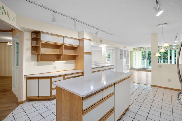5011 Lake Ave Unit 105, White Bear Lake, MN 55110 - kitchen with track lighting, light countertops, open shelves, light tile patterned flooring, and a textured ceiling