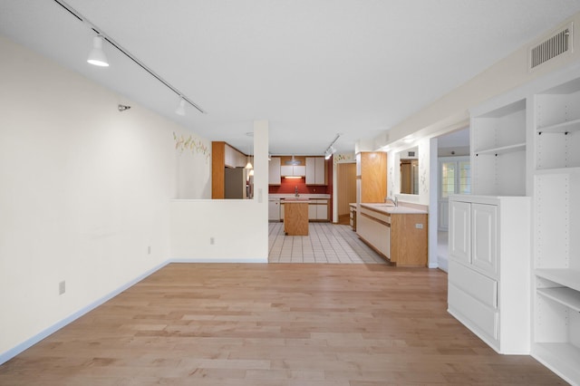 5011 Lake Ave Unit 105, White Bear Lake, MN 55110 - kitchen with rail lighting, stainless steel refrigerator with ice dispenser, light wood finished floors, and open floor plan