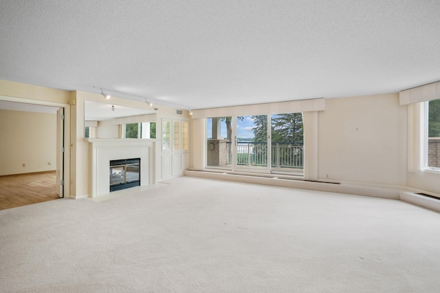 5011 Lake Ave Unit 105, White Bear Lake, MN 55110 - unfurnished living room featuring carpet, a fireplace with flush hearth, and a textured ceiling