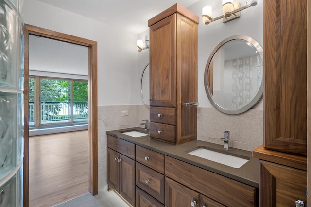 5011 Lake Ave Unit 105, White Bear Lake, MN 55110 - bathroom featuring double vanity, tile walls, and wainscoting