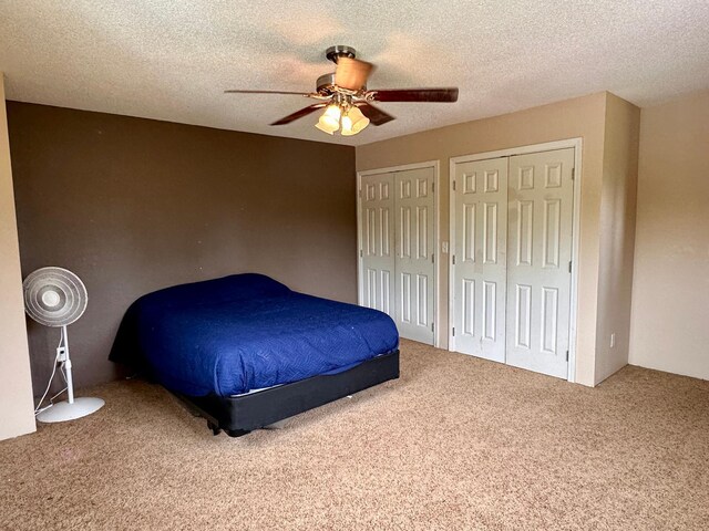 4984 Tower Rd, Moose Lake, MN 55767 - carpeted bedroom featuring two closets, a ceiling fan, and a textured ceiling