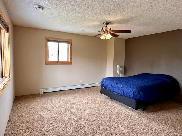 4984 Tower Rd, Moose Lake, MN 55767 - bedroom with a baseboard heating unit, carpet flooring, a textured ceiling, and ceiling fan