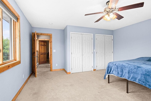 4984 Tower Rd, Moose Lake, MN 55767 - bedroom featuring two closets, light carpet, multiple windows, and a ceiling fan
