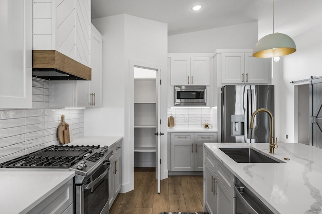 9930 14th Cir NE, Saint Michael, MN 55376 - kitchen with appliances with stainless steel finishes, premium range hood, a barn door, dark wood-style floors, and hanging light fixtures