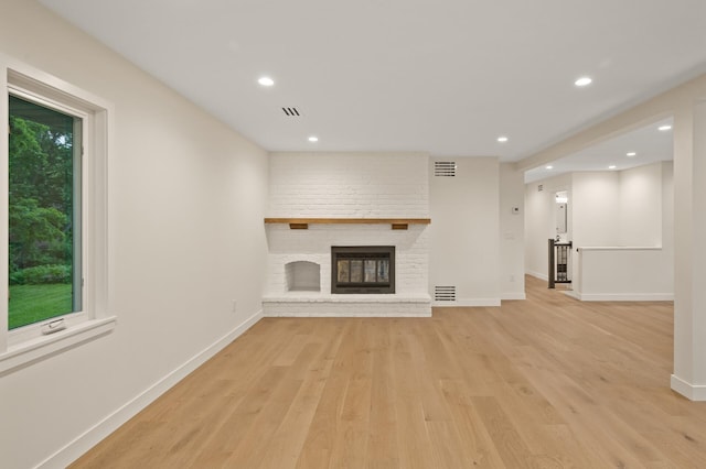 2022 Lake Rd, Minnetonka Beach, MN 55391 - unfurnished living room featuring light wood-style flooring, recessed lighting, and a brick fireplace