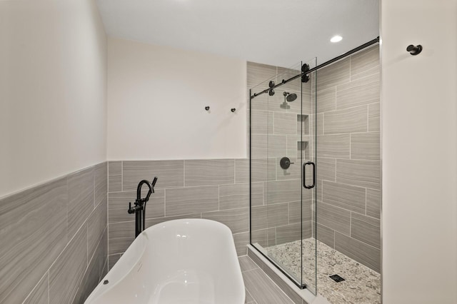 2022 Lake Rd, Minnetonka Beach, MN 55391 - full bathroom featuring a soaking tub, a shower stall, tile walls, and wainscoting