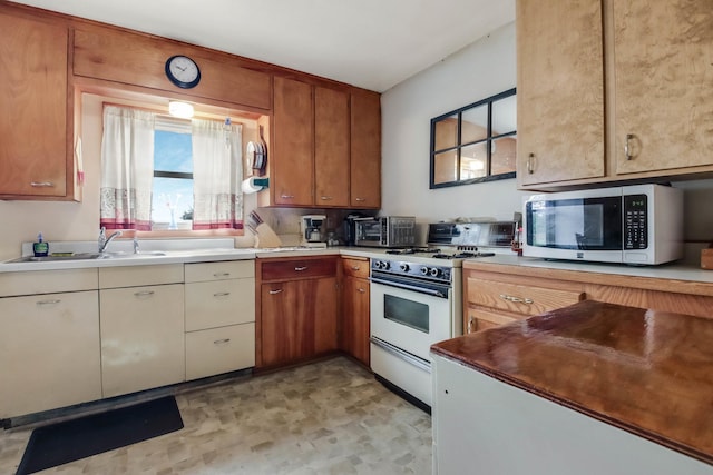 N2498 50th St, Union Twp, WI 54761 - kitchen with white gas range, stainless steel microwave, light countertops, and brown cabinets