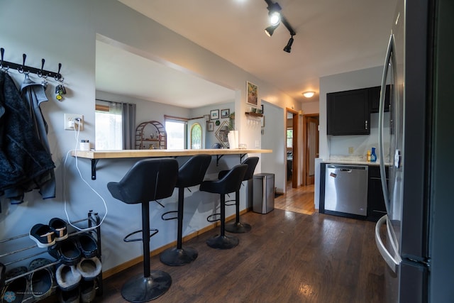 2901 10th Ave N, Fargo, ND 58102 - kitchen featuring stainless steel appliances, a breakfast bar, dark wood-style floors, light countertops, and dark cabinetry