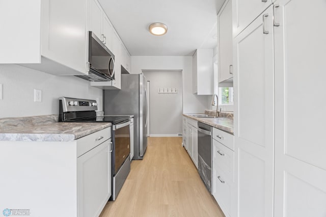 1031 7th St W, West Fargo, ND 58078 - kitchen with appliances with stainless steel finishes, light wood finished floors, white cabinetry, and light countertops