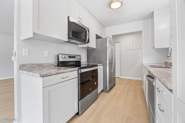 1031 7th St W, West Fargo, ND 58078 - kitchen featuring stainless steel appliances, light wood-type flooring, white cabinets, and light countertops