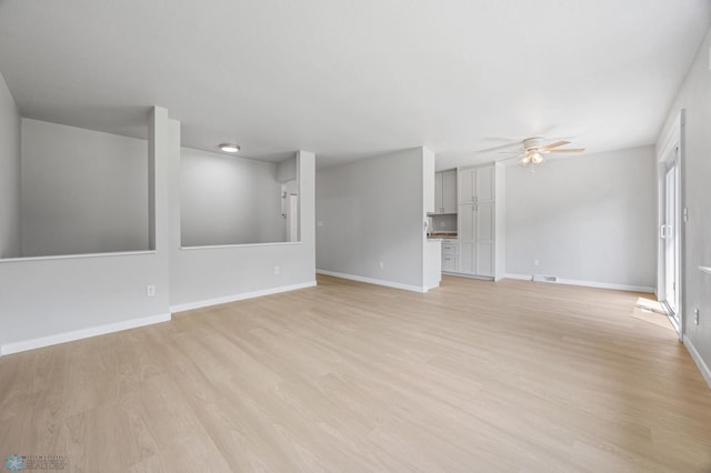 1031 7th St W, West Fargo, ND 58078 - unfurnished living room featuring a ceiling fan and light wood-style floors