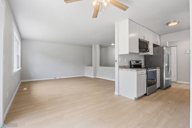 1031 7th St W, West Fargo, ND 58078 - kitchen with stainless steel appliances, a ceiling fan, white cabinets, and light wood finished floors