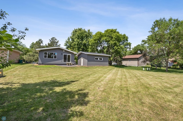 1031 7th St W, West Fargo, ND 58078 - back of house with an outdoor structure and a lawn