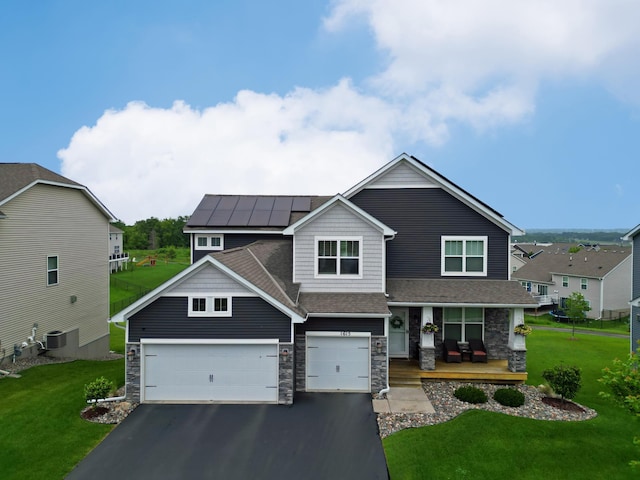 1615 Tamarack Rd, Shakopee, MN 55379 - view of front of house featuring a porch, driveway, stone siding, solar panels, and a front yard