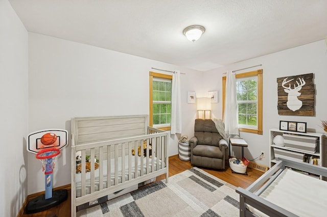 9372 71st St NE, Spicer, MN 56288 - bedroom featuring wood finished floors and a nursery area